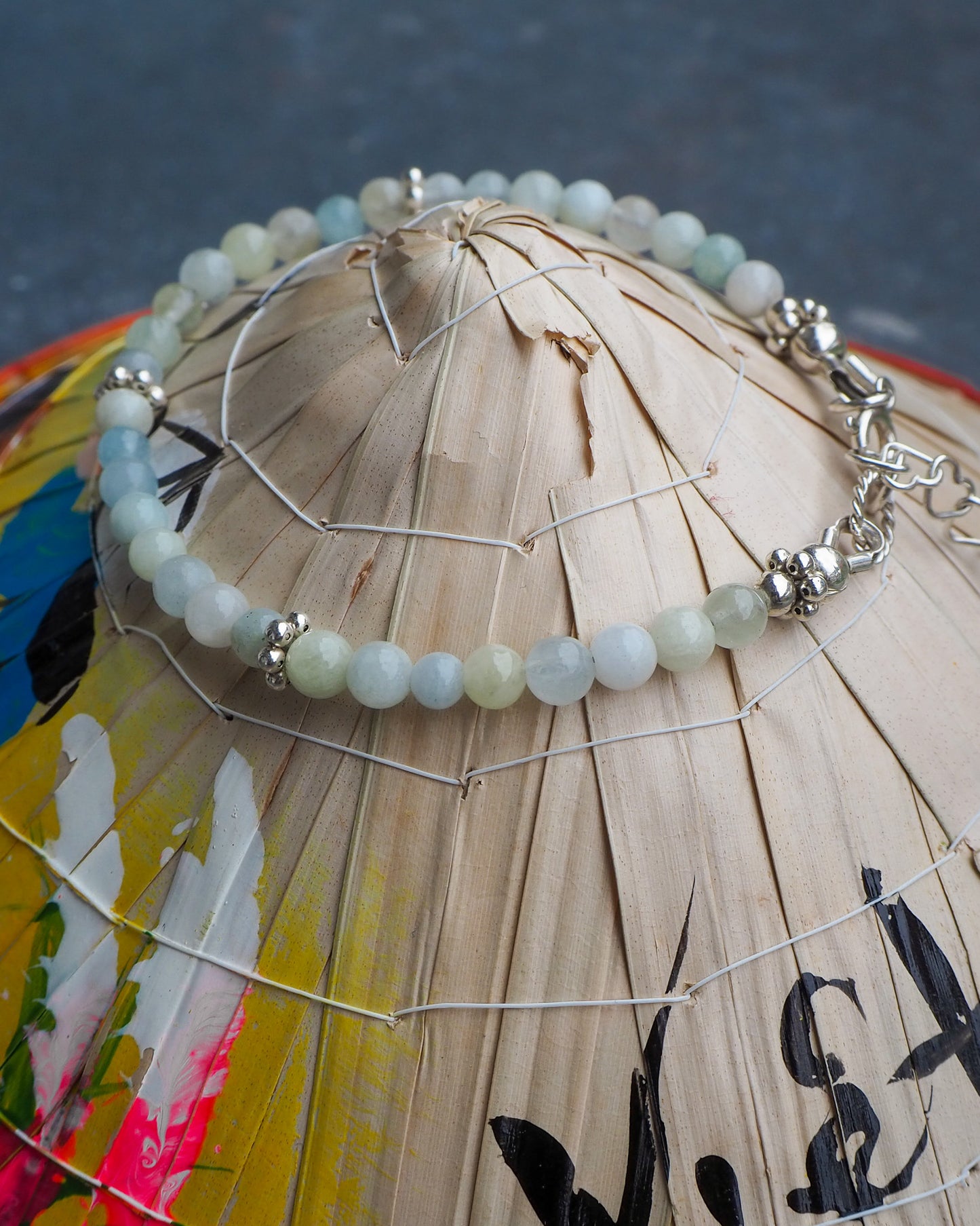 Aquamarine and silver bracelet displayed on a traditional Vietnamese hat –-handcrafted gemstone jewelry by elswre